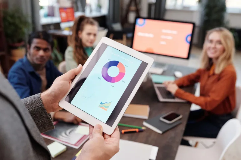 A team reviewing digital marketing charts on a tablet.